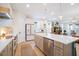 Modern kitchen with stainless steel appliances, a large island, white cabinetry, and an open view to the living room at 6542 Rover Way, St Cloud, FL 34771