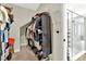 Organized walk-in closet with shelving and a variety of clothing items, plus a view to an adjacent bathroom at 6542 Rover Way, St Cloud, FL 34771