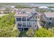 Stunning aerial view showcasing the multi-story home with balconies, hot tub, and rooftop deck, surrounded by lush greenery at 6771 Turtlemound Rd, New Smyrna Beach, FL 32169