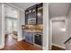 Bar area with dark cabinetry, a beverage cooler, and a view of the bedroom, and balcony at 6771 Turtlemound Rd, New Smyrna Beach, FL 32169