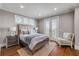 This bedroom features a balcony, recessed lighting, white trim, hardwood floors and an accent chair at 6771 Turtlemound Rd, New Smyrna Beach, FL 32169