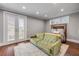 Bedroom offers a plush sofa and hardwood floors with French doors opening to a balcony at 6771 Turtlemound Rd, New Smyrna Beach, FL 32169