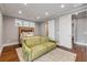 This bedroom features an olive-colored couch, with recessed lighting, a sliding door closet and hardwood floors at 6771 Turtlemound Rd, New Smyrna Beach, FL 32169