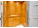 Elevator with wood paneling, a metal handrail, and tile flooring at 6771 Turtlemound Rd, New Smyrna Beach, FL 32169