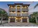 Luxurious three-story beach house with a paver driveway, garage, and multiple balconies at 6771 Turtlemound Rd, New Smyrna Beach, FL 32169