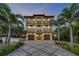 Stunning three-story home boasting multiple balconies and a beautifully paved driveway lined with palm trees at 6771 Turtlemound Rd, New Smyrna Beach, FL 32169