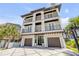 Stately three-story home boasts multiple balconies, three-car garage, and elegant curb appeal at 6771 Turtlemound Rd, New Smyrna Beach, FL 32169