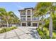 Three-story home features multiple balconies, lush landscaping, and a spacious driveway at 6771 Turtlemound Rd, New Smyrna Beach, FL 32169