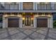 Grand front entrance with a double door, flanked by topiaries and leading to a spacious two-car garage at 6771 Turtlemound Rd, New Smyrna Beach, FL 32169