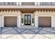 Elegant front entrance with a double door and topiaries, leading to a spacious two-car garage at 6771 Turtlemound Rd, New Smyrna Beach, FL 32169