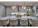 Modern kitchen features an eat-in island with marble countertop, stainless steel hood, and custom lighting fixtures at 6771 Turtlemound Rd, New Smyrna Beach, FL 32169