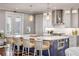 Bright kitchen features a large island with bar seating, stainless steel hood, and white cabinets for a modern feel at 6771 Turtlemound Rd, New Smyrna Beach, FL 32169