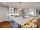 Open kitchen features large island with seating and marble counters, custom cabinets, and stainless steel appliances at 6771 Turtlemound Rd, New Smyrna Beach, FL 32169
