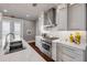 Modern kitchen features stainless steel appliances, white cabinets, marble countertops and backsplash, and hardwood floors at 6771 Turtlemound Rd, New Smyrna Beach, FL 32169