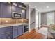 Elegant kitchenette features custom cabinets, wine cooler, mosaic backsplash, and stainless steel appliances at 6771 Turtlemound Rd, New Smyrna Beach, FL 32169