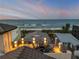 Rooftop deck overlooking the ocean, complete with a cozy fire pit and seating area for relaxation at 6771 Turtlemound Rd, New Smyrna Beach, FL 32169