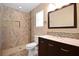 Tiled bathroom with step in shower, dark vanity with light countertop and natural lighting at 682 Ferncliff Dr, Port Orange, FL 32127