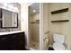 Bathroom featuring a tiled shower, a dark wood vanity, a toilet, and floating shelves at 682 Ferncliff Dr, Port Orange, FL 32127