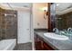 Bathroom with tiled shower and flooring and a dark wood vanity and a decorative light fixture at 682 Ferncliff Dr, Port Orange, FL 32127