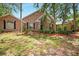 Charming single-story brick home with arched windows, lush landscaping, and mature trees at 682 Ferncliff Dr, Port Orange, FL 32127