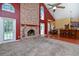 Spacious living room with a brick fireplace, carpeted and wood floors, and large windows for natural light at 682 Ferncliff Dr, Port Orange, FL 32127