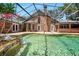 Back exterior view of a brick home with a screened swimming pool with waterfall features at 682 Ferncliff Dr, Port Orange, FL 32127