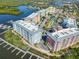 Aerial view of the community with boat docks, tennis courts, parking, colorful buildings and waterfront access at 7 Riverwalk Dr # 205, New Smyrna Beach, FL 32169