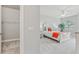 Bright bedroom featuring a bed with colorful accents, alongside a view of a closet and a glimpse of the outdoors at 7 Riverwalk Dr # 205, New Smyrna Beach, FL 32169