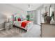 Cozy bedroom with a bright window, a white bed with colorful pillows, and carpet flooring at 7 Riverwalk Dr # 205, New Smyrna Beach, FL 32169