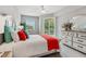 Comfortable bedroom featuring a white bed with colored pillows, a dresser, and a private balcony at 7 Riverwalk Dr # 205, New Smyrna Beach, FL 32169
