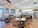 A dining area features multiple round tables and chairs, a kitchen with modern appliances, and light-colored wood floors at 7 Riverwalk Dr # 205, New Smyrna Beach, FL 32169
