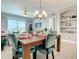 Dining room with table set for dinner, chandelier, and sliding glass doors to the balcony at 7 Riverwalk Dr # 205, New Smyrna Beach, FL 32169