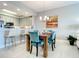 Dining area with modern chandelier, seating for four, and open view to the kitchen at 7 Riverwalk Dr # 205, New Smyrna Beach, FL 32169