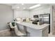 A sleek kitchen featuring white cabinets, granite countertops, stainless steel appliances, and bar seating at 7 Riverwalk Dr # 205, New Smyrna Beach, FL 32169