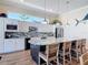 A bright kitchen with white cabinets, granite countertops, stainless steel appliances, and a large island with seating at 7 Riverwalk Dr # 205, New Smyrna Beach, FL 32169