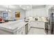 A modern kitchen with white cabinets, granite countertops, stainless steel appliances, and bar seating at 7 Riverwalk Dr # 205, New Smyrna Beach, FL 32169