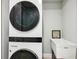 Modern, stacked washer and dryer set in a well-lit laundry room with a utility sink at 7 Riverwalk Dr # 205, New Smyrna Beach, FL 32169