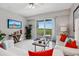 Bright living room with sliding glass doors to balcony offering serene outdoor views, stylish furniture, and tiled floors at 7 Riverwalk Dr # 205, New Smyrna Beach, FL 32169