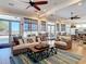 The living room features a comfortable sofa, ceiling fans, and a view of the pool area through the windows at 7 Riverwalk Dr # 205, New Smyrna Beach, FL 32169