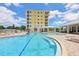 Community pool featuring a stepped entry, lounge chairs and lush landscaping and building in the background at 7 Riverwalk Dr # 205, New Smyrna Beach, FL 32169
