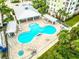 Aerial view of a stunning pool area with a unique shape, lounge chairs, and shaded cabanas at 7 Riverwalk Dr # 205, New Smyrna Beach, FL 32169