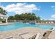 Community swimming pool with lounge chairs and lush landscaping on a sunny day at 7 Riverwalk Dr # 205, New Smyrna Beach, FL 32169