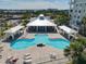 Aerial view of the community pool area surrounded by palm trees and lounge chairs at 7 Riverwalk Dr # 205, New Smyrna Beach, FL 32169