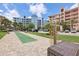 Community recreation area including a bocce court surrounded by palm trees, parking, and multi-story condo buildings at 7 Riverwalk Dr # 205, New Smyrna Beach, FL 32169