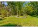 Tranquil backyard area with mature trees, a decorative fountain, and manicured lawn at 706 S Timberlane Dr, New Smyrna Beach, FL 32168