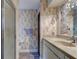 Bathroom with vanity, sink, mirror, glass door shower, hardwood floors, and floral wallpaper at 706 S Timberlane Dr, New Smyrna Beach, FL 32168
