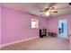 Bedroom with pink walls, carpeted floors, ceiling fan and a small storage area for toys at 706 S Timberlane Dr, New Smyrna Beach, FL 32168