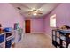 Bedroom with pink walls, carpeted floors, ceiling fan and storage units for toys and decor at 706 S Timberlane Dr, New Smyrna Beach, FL 32168