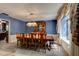 Formal dining room with elegant chandelier, large window, and classic wood furniture, perfect for Gathering gatherings at 706 S Timberlane Dr, New Smyrna Beach, FL 32168