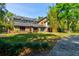 Charming brick home with a striking turquoise door, enhanced by lush landscaping for a welcoming and stylish curb appeal at 706 S Timberlane Dr, New Smyrna Beach, FL 32168